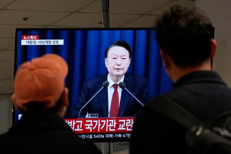 Personas ven un televisor con la imagen del presidente surcoreano Yoon Suk Yeol en una terminal de autobuses en Seúl, Corea del Sur, el martes 3 de diciembre de 2024. (AP Foto/Ahn Young-joon)