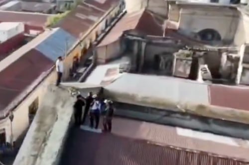 Video aéreo. Hombre trepa en la parte alta de la municipalidad de Quetzaltenango