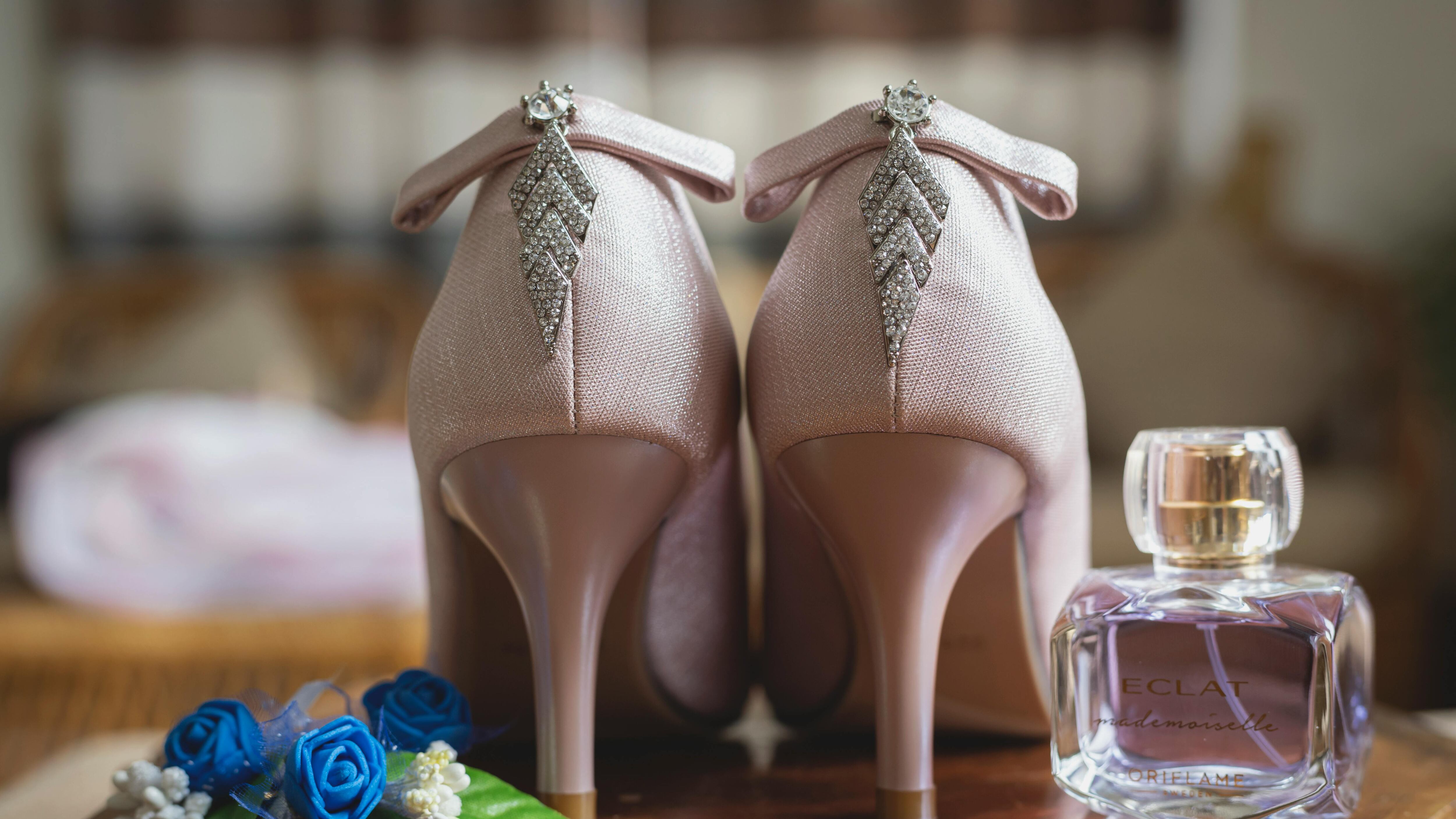 Frasco de perfume ao lado de salto agulha rosa