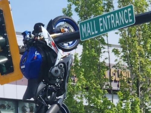 Cámara de seguridad graba el momento en el que luego de una fuerte colisión motocicleta queda colgada de un semáforo