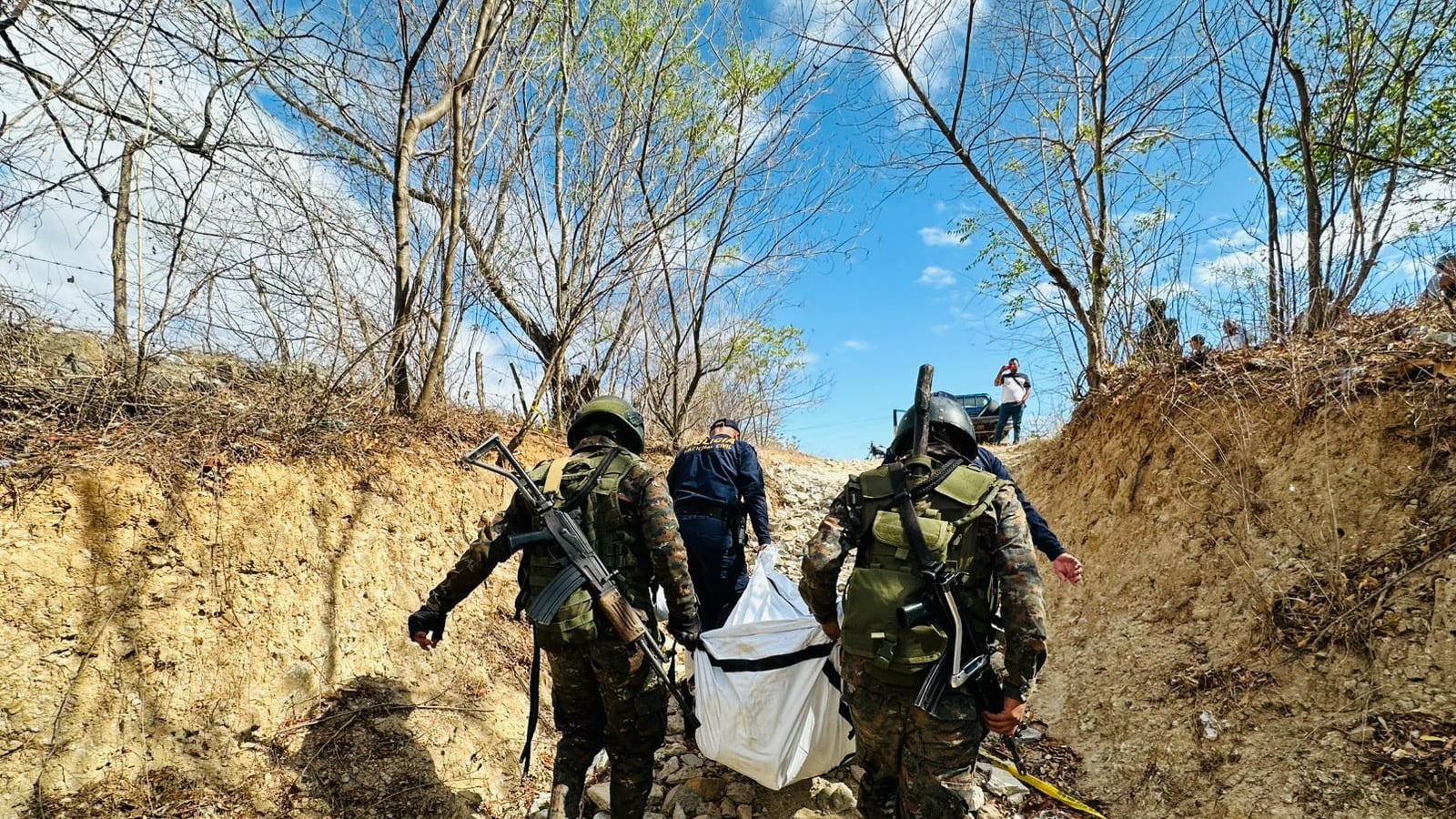 Soldados retiran el cuerpo localizado en los alrededores del Centro de Detención Preventiva para Hombres y Mujeres "Los Jocotes", ubicado en Zacapa.