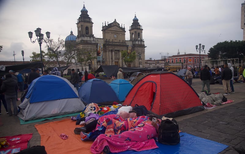 Maestros del STEG descansan junto a sus tiendas de acampar en el Parque Central.