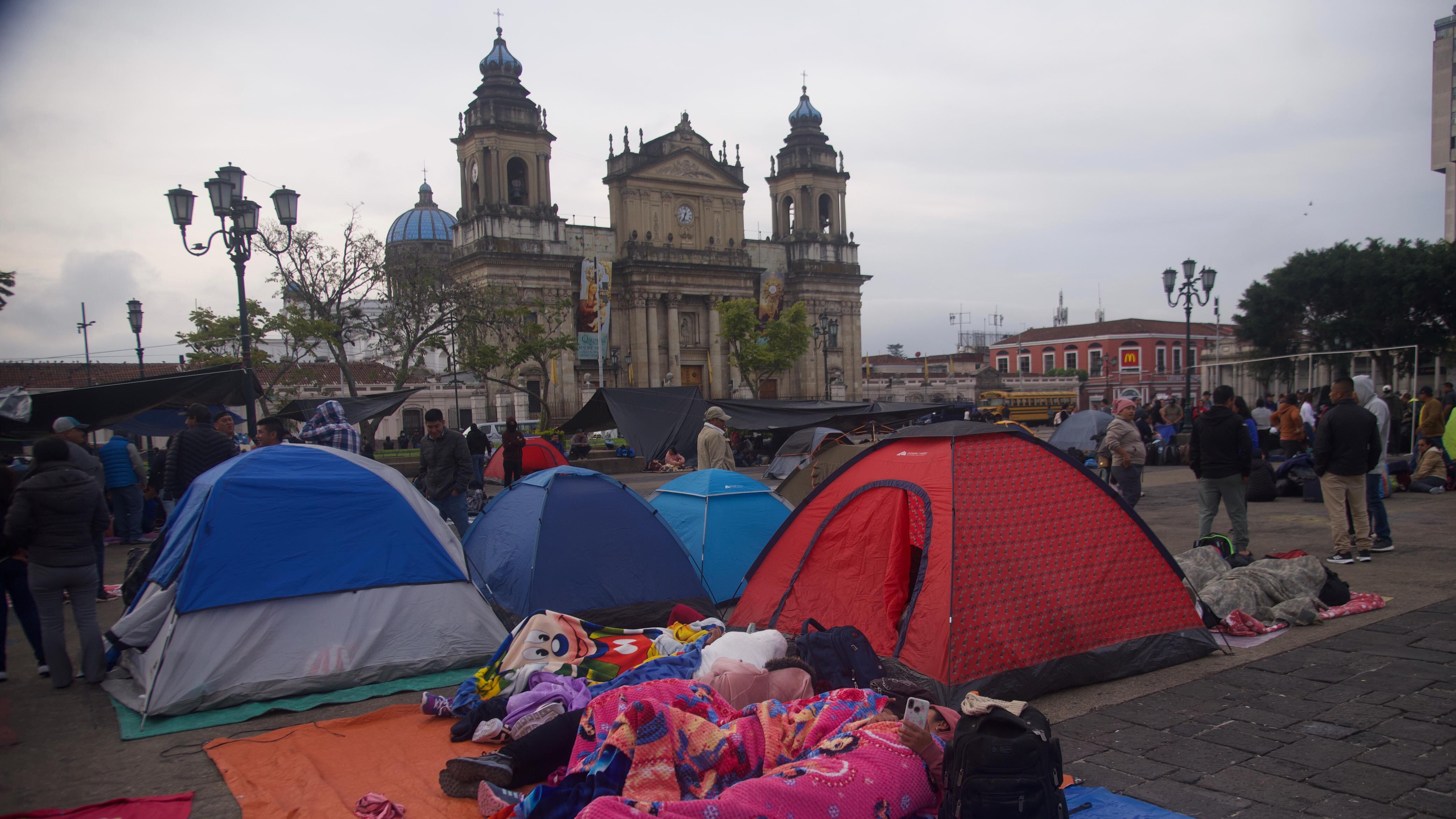 Maestros del STEG descansan junto a sus tiendas de acampar en el Parque Central.