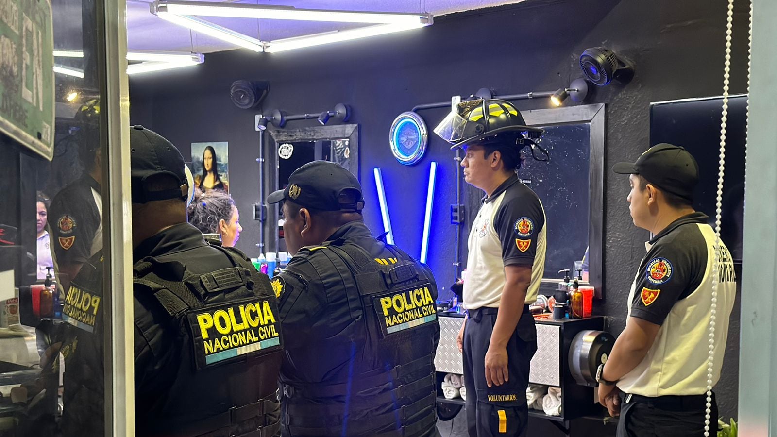 Agentes de PNC y Bomberos Voluntarios acuden al lugar donde falleció un hombre por impactos de bala dentro de una barbería en zona 18. Foto CVB