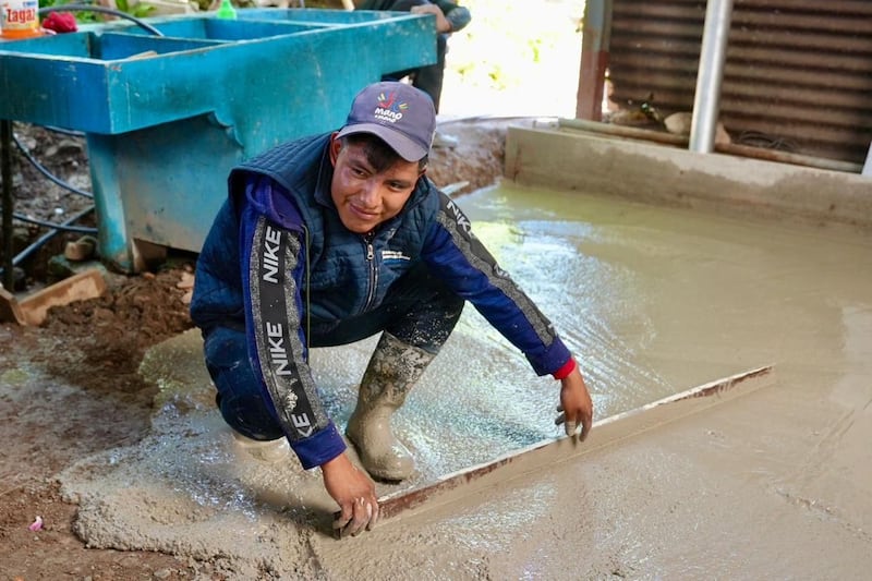Voluntarios y autoridades trabajan en la instalación de pisos de cemento en comunidades de Huehuetenango. Foto: Embajada de EE.UU.